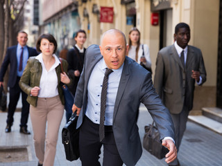 Hurrying businessman running on city street