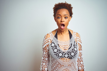 Young african american woman with afro hair wearing a bikini over white isolated background afraid and shocked with surprise expression, fear and excited face.