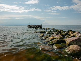 Fototapeta na wymiar Old stone pier in the sea, Tuja, The Gulf of Riga. Baltic Sea