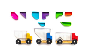 Bright toy cars with a transparent body. Multi-colored blocks - puzzles up above the cars. isolated white background. Concept delivery, trucking, cargo and educational games for children