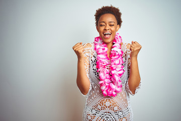 Young african american woman with afro hair wearing flower hawaiian lei over isolated background...