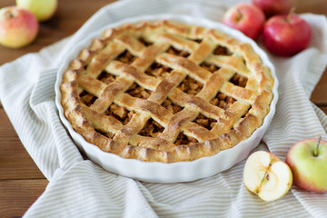 food, culinary and pastry concept - close up of apple pie in baking mold on kitchen towel