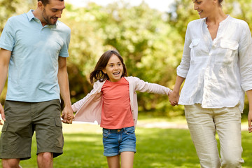 family, leisure and people concept - happy mother, father and little daughter walking in summer park and having fun