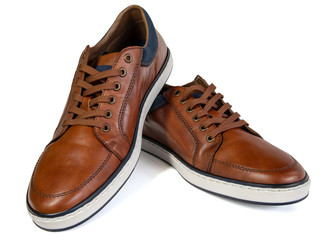 A pair of brown trainers over a white background.