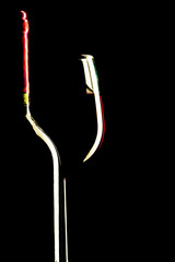 The outline of a glass with a bottle on a black background