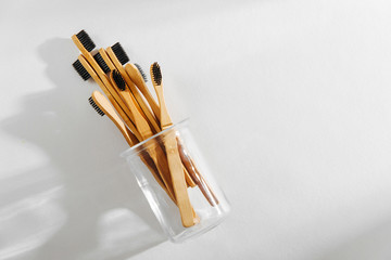Eco friendly bamboo toothbrushes with black bristle, bathroom essentials on white background. Zero waste, plastic free concept.