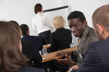 African American business male talking with people during presentation