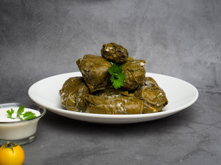 Traditional georgian dolma in grape leaves on rustic wooden table with copyspace