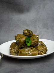 Traditional georgian dolma in grape leaves on rustic wooden table with copyspace