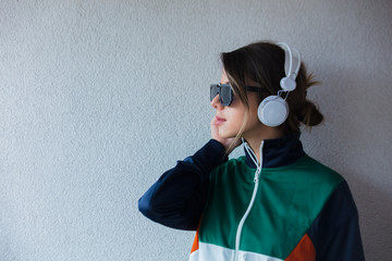 Young woman in 90s style clothes with headphones