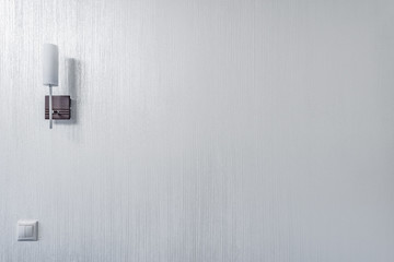 White lamp on the white living room wall.