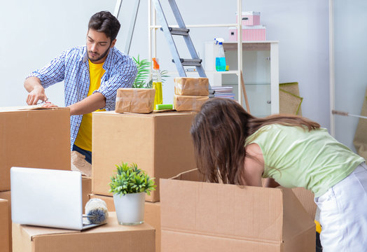 Young family unpacking at new house with boxes