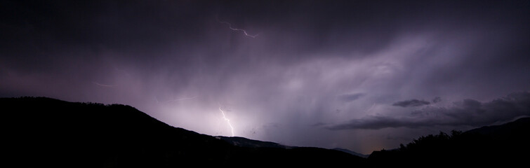a dangerous storm in a summer night full of lighting bolts with view above the austrian city of leoben to the east