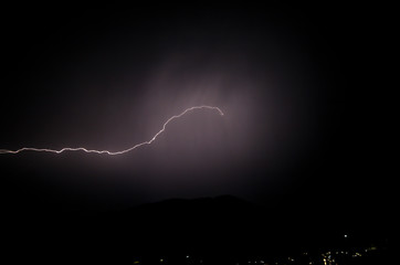 a dangerous storm in a summer night full of lighting bolts with view above the austrian city of leoben to the east