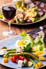 vegetarischer Salade Nicoise auf dunklem Holz