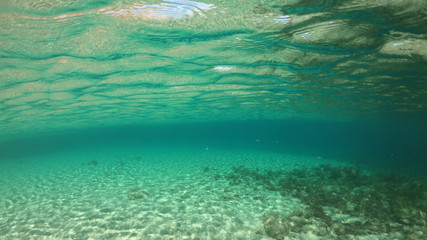Fototapeta na wymiar Split of above and underwater photo of iconic and beautiful small cove and sandy clear turquoise beach of Agios Sostis, Mykonos island, Greece