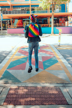 Rear view of man with rainbow backpack and baseball cap