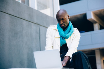Low angle view of man wearing high heels working on laptop