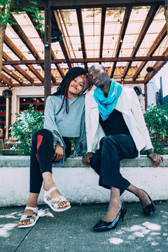 Man and woman pose together on cement wall