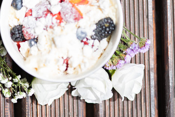 Bowl of healthy fresh fruit salad with cheese on the wooden background.