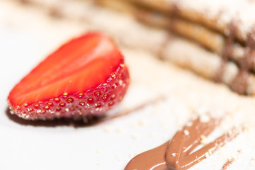 Delicious pancake with strawberry and cream on the plate