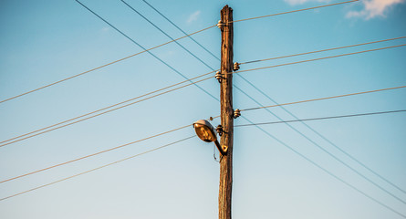 Old wooden electric pole with cables