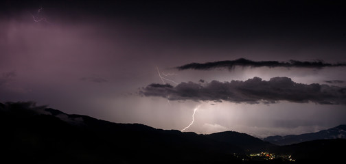 a dangerous storm in a summer night full of lighting bolts with view above the austrian city of leoben to the east