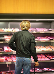 man purchasing a packet of meat at the supermarket	