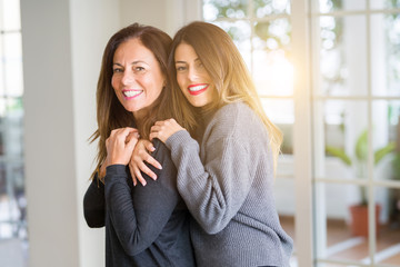 Beautiful family of mother and daughter together, hugging and kissing at home