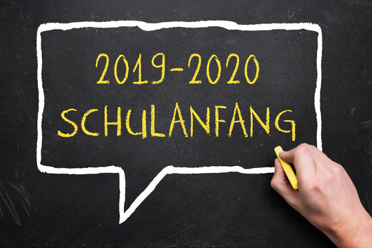 Hand schreibt "2019-2020 Schulanfang" auf Wandtafel