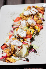 Chicken salad with tomatoes, sweet corn, cucumber, cream and lettuce. Home made food. Concept for a tasty and healthy meal.