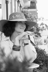 sensual portrait of woman in hat cafe on city street