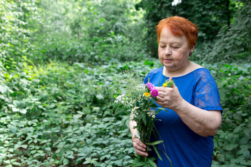 elderly woman park flowers hands bouquet  green nature