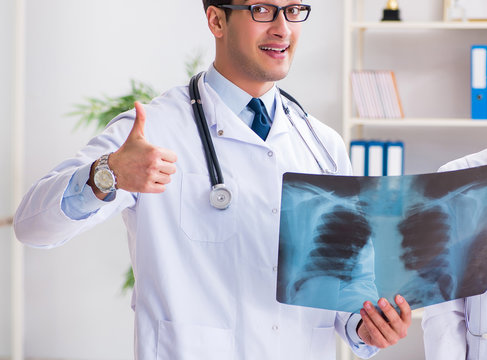 Two doctors examining x-ray images of patient for diagnosis