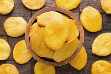 dried fruit, halves peach in wooden bowl, top view.