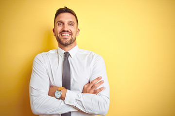 Young handsome business man wearing elegant white shirt over yellow isolated background happy face...