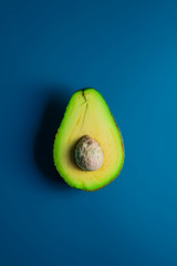 Avocado Isolated on Dark Blue background wis headphones. Music Symbol or Fresh Organic Fruit for Healthy Lifestyle Concept - obrazy, fototapety, plakaty