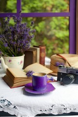 Still life with lavender, coffee in a purple cup, books by the window. Romantic still life with lavender.