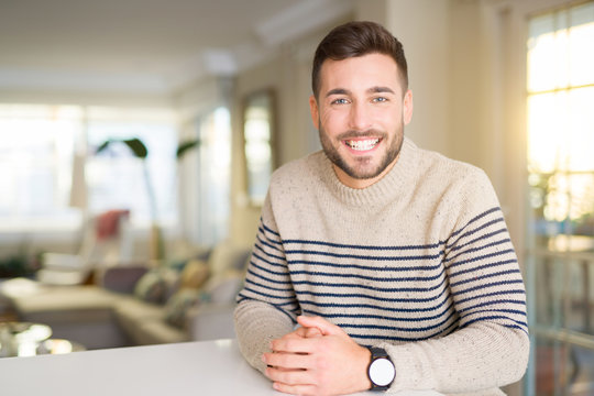 Young handsome man at home with a happy and cool smile on face. Lucky person.