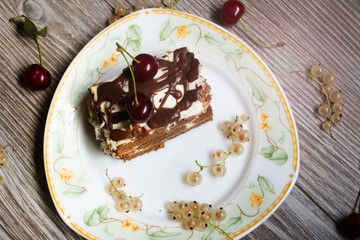 Chocolate cake with cherries on wooden background