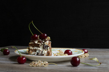 Black Forest Cake topping cherry putting on the white plate. Black background