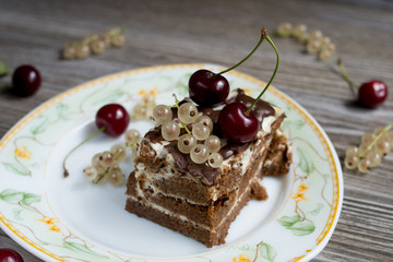 Chocolate cake with cherries on wooden background