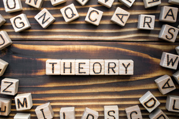 word theory composed of wooden cubes with letters, explain a fact or event concept, scattered...