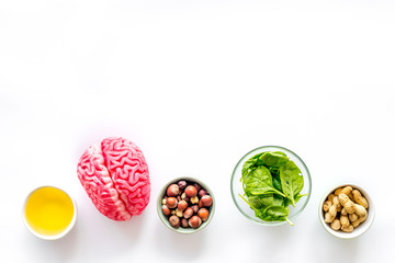 Energy food for brain work with peanut, hazelnut, seed-oil, spinage on white background top view space for text