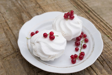 Homemade pink marshmallow and pavlova cake with strawberry, blackberry, currant, cherry and mint leaf.