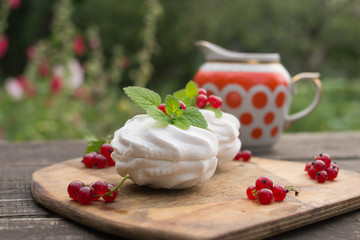 Homemade pink marshmallow and pavlova cake with strawberry, blackberry, currant, cherry and mint leaf.