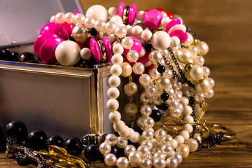 Aluminium case full of different jewelry on wooden table