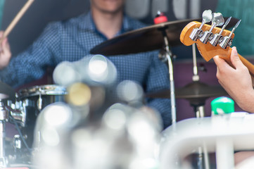 Scene with a guitar player and a drummer playing, no face picture