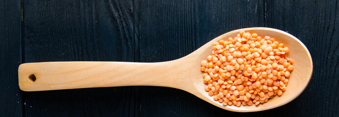 Spoons filled with uncooked lentil for soup