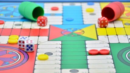 Juego del parchís con el tablero, las fichas de colores y los dados de juego